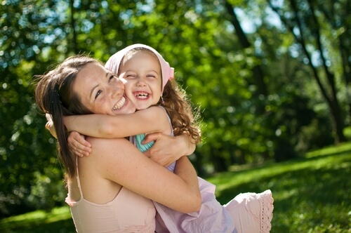 Madre e hija abrazadas sonriendo