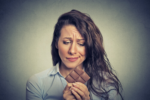 Mujer con tableta de chocolate en las manos deseando comérsela