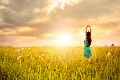 Mujer feliz viendo arco iris