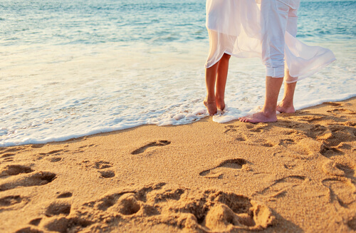 Piernas de una pareja dándose un beso en la playa