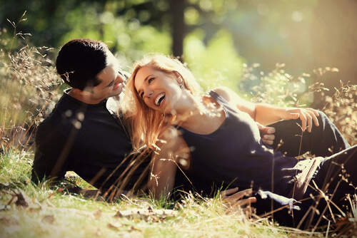 Pareja tumbada en el suelo sonriendo