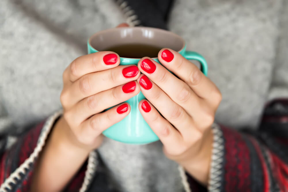 Mujer tomando una infusión para el Síndrome premenstrual
