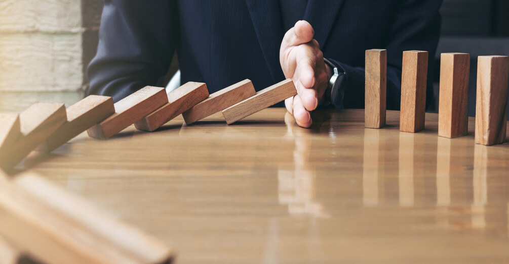 Mano frenando avance fichas de dominó