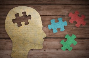 Perfil de cabeza con piezas de puzzles a su alrededor