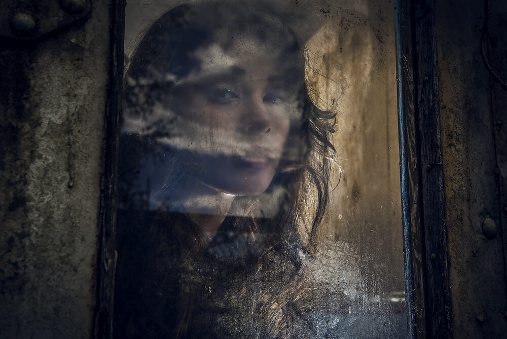 Mujer mirando a través de una ventana