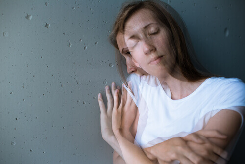 Mujer abrazándose con pensamientos negativos