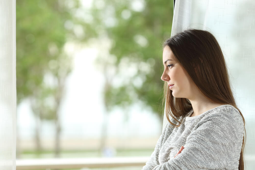 Mulher melancólica pensando em como eliminar a dependência emocional de sua vida.