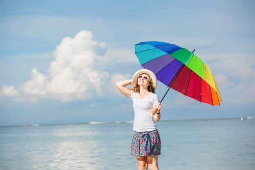 rengarenk şemsiyesi ile sahilde mutlu bir kadın
