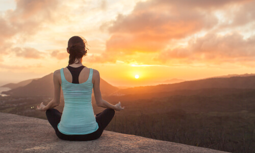 Mujer haciendo yoga al aire libre