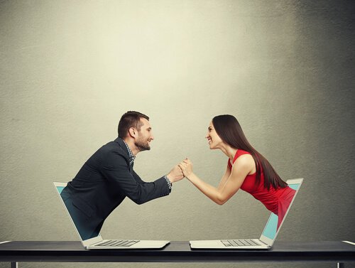 PAreja saliendo de un ordenador representando relaciones cibernéticas