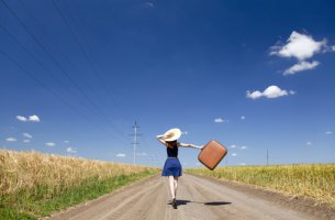 Mujer con maleta pensando en el cambio
