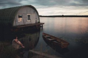 Mujer con miedo sentada al lado del río