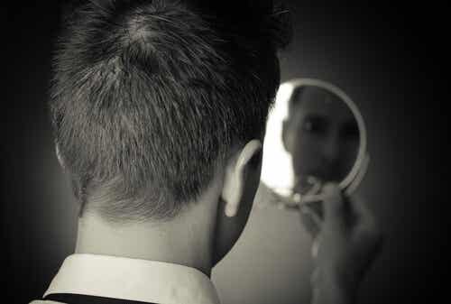 Mann blickt in den Spiegel und stellt sich die Frage, warum emotionale Intelligenz so wichtig ist