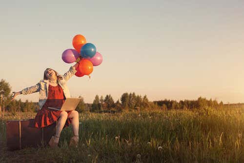 Mujer con pensamiento positivo sujetando globos de colores
