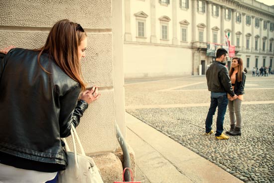Mujer celosa espiando a alguien que cree es de su propiedad