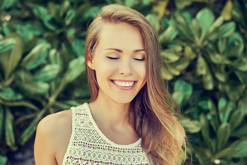 Mujer con los ojos cerrados sonriendo