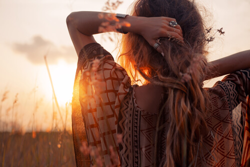 Mujer de espaldas disfrutando la serenidad del atardecer