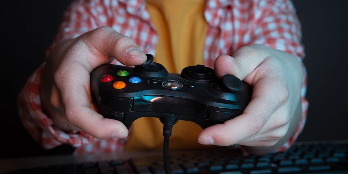 Niño con el mando de la consola jugando a videojuegos