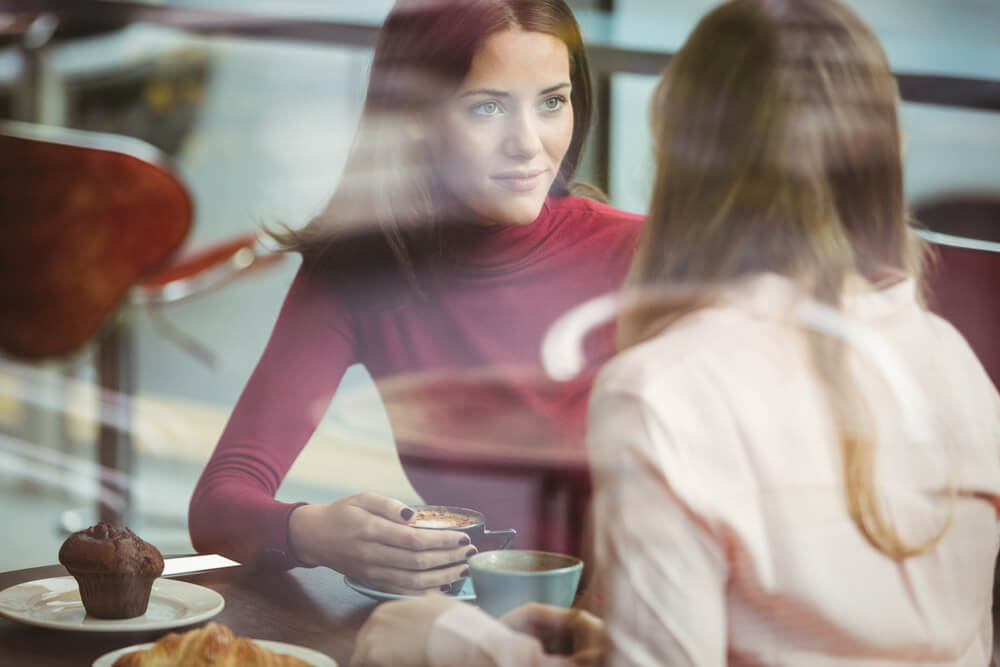 amigas hablando en cafetería simbolizando el arte de expresar el dolor emocional