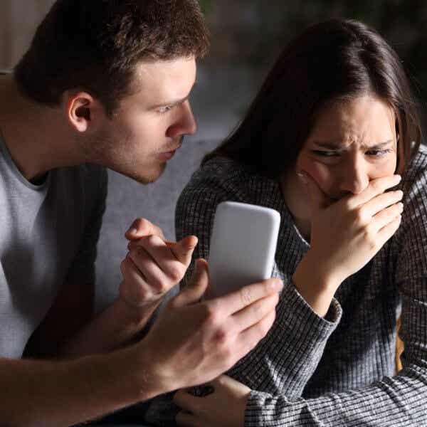 Hombre celoso revisando el móvil de su pareja representando la neurobiología de los celos