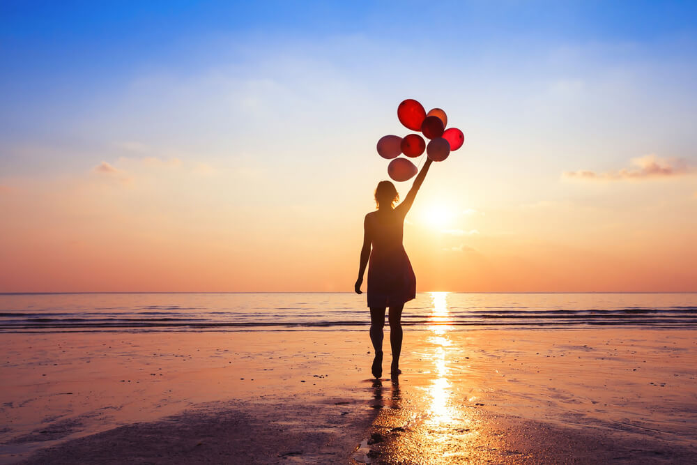 Mujer en una playa con globos