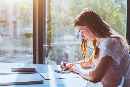 Mujer escribiendo sus errores 
