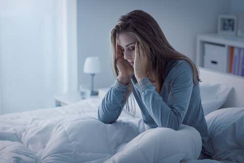 Mujer con problemas de sueño en la cama sufriendo Epilepsia del lóbulo frontal