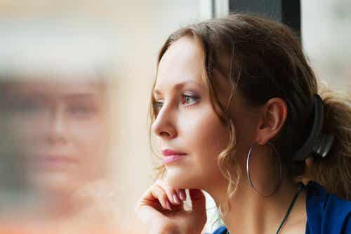 Mujer mirando por una ventana en soledad