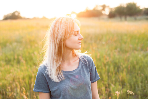 Mujer con los ojos cerrados reflexionando sobre sus necesidades