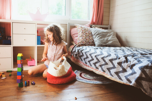 Niña recogiendo los juguetes
