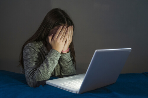 Niña tapándose la cara por tener complejo de inferioridad