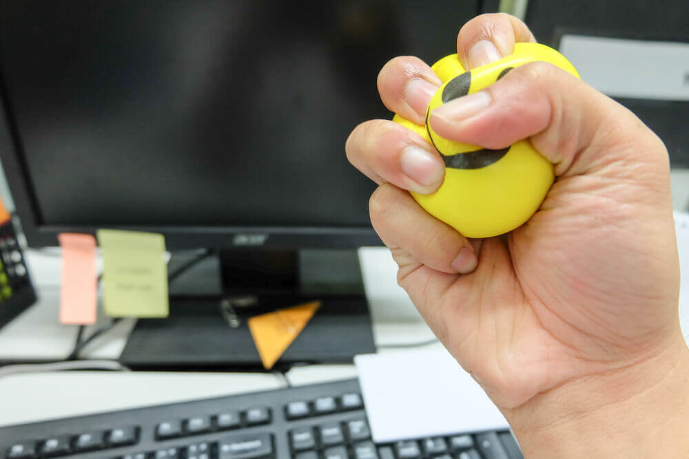 Mano apretando una pelota para controlar el estrés