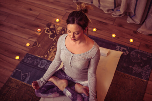 Mujer meditando entre velas