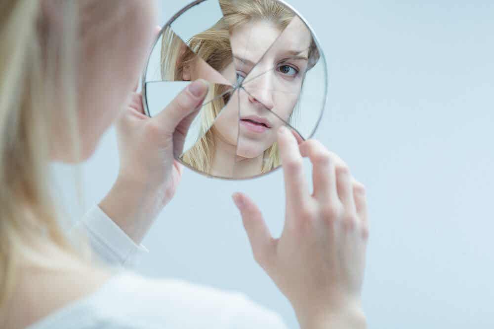 Mujer mirándose en espejo roto