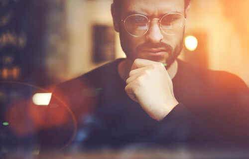 Mężczyzna w okularach myślący o strategii mentalnej