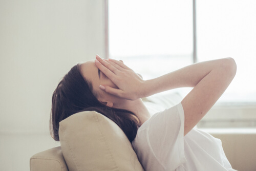 Woman with hands on her face feeling emotional pain