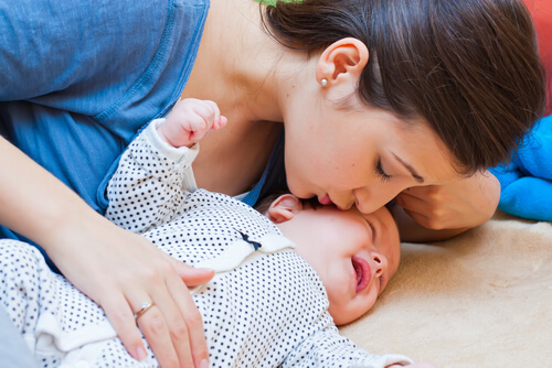 Madre acariciando y besando a su bebé