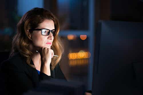 Kvinde i mørke ser på computer