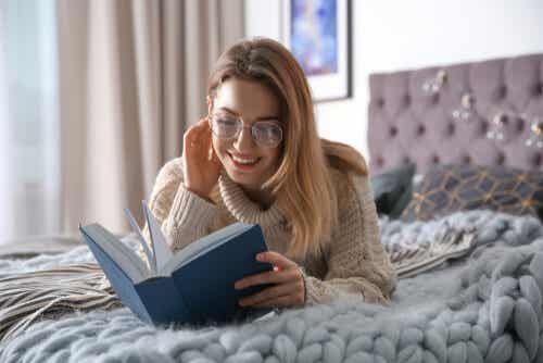 Kvinne leser bok på rommet sitt