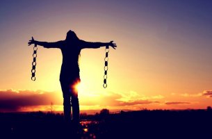 Mujer con cadenas rotas que se ha liberado de sus propias reglas