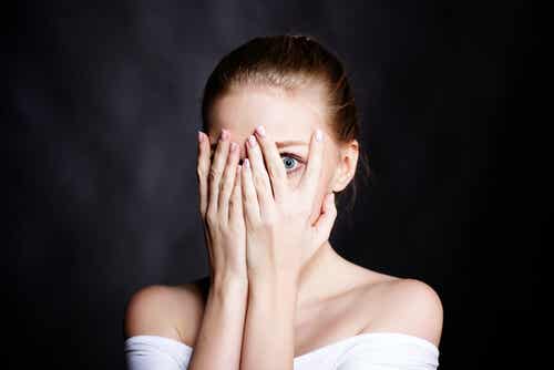 Vrouw verbergt haar emoties door haar gezicht te bedekken