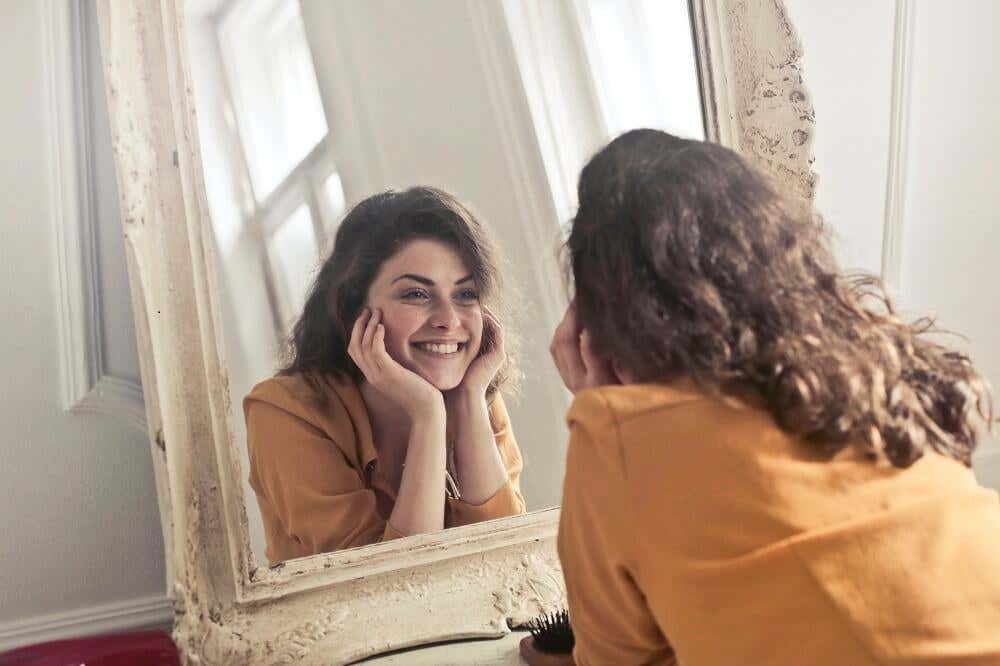 Mujer mirándose al espejo sonriente