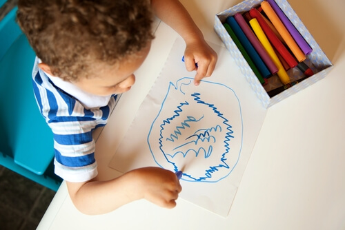 Niño dibujando garabatos en papel