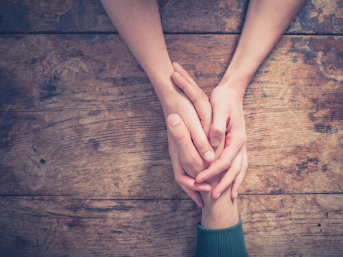 Personas tomadas de la mano perdonándose