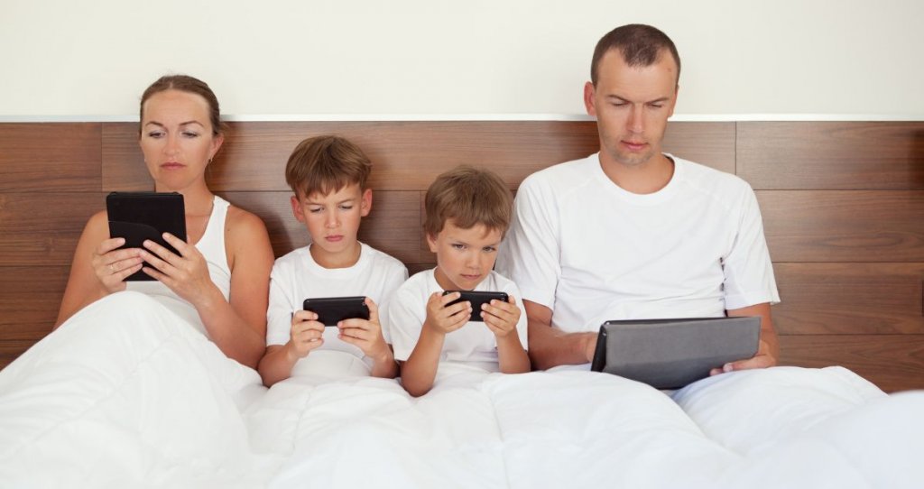 Familia absorta con la tecnología representando aprender a escuchar