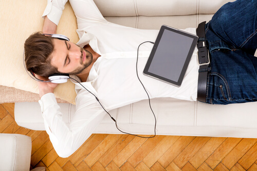 Hombre escuchando música acostado