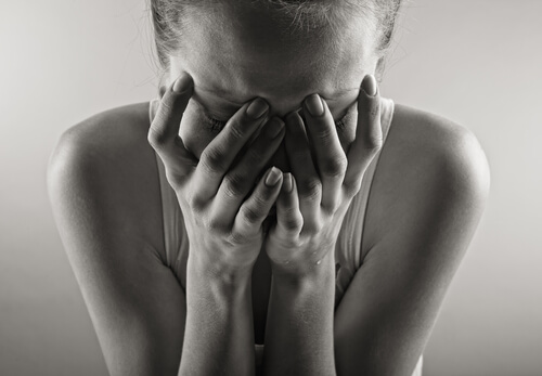 Mujer llorando con el rostro tapado