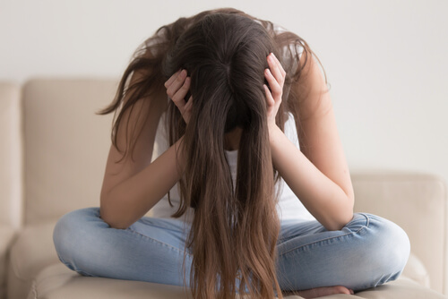 Mujer triste con las manos en la cabeza