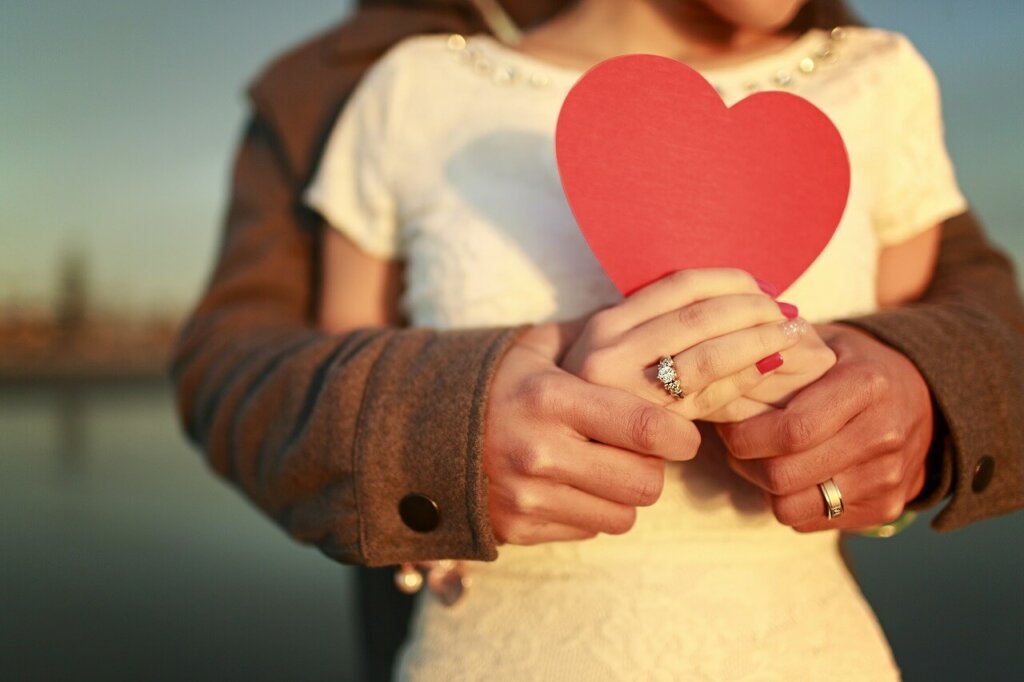 Personas abrazadas con corazón intentando lograr que el amor funcione según Robert J. Sternberg