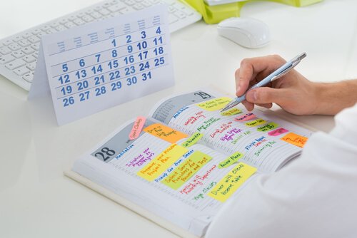 Hombre planificando su gestión del tiempo en una agenda